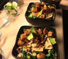 three black bowls filled with food on top of a counter