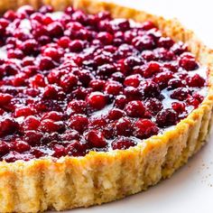 a close up of a pie with cranberries on it