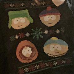 an ugly sweater with the faces of people wearing hats and scarves on it's chest