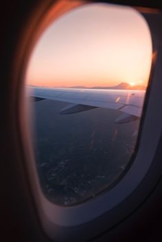 the view out an airplane window at sunset