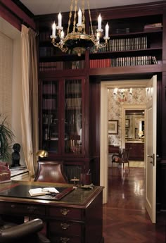 a large wooden desk sitting in front of a book shelf filled with lots of books