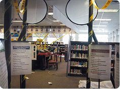 there are several tennis rackets hanging from the ceiling in this library with bookshelves