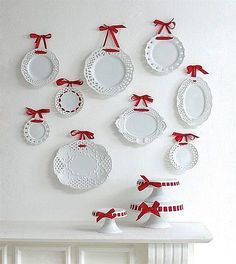 white plates with red bows are hanging on the wall