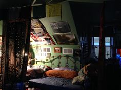 a bed room with a neatly made bed and pictures on the wall above it at night