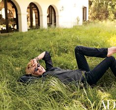 a man laying on the ground in tall grass