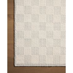 a white rug on top of a wooden floor