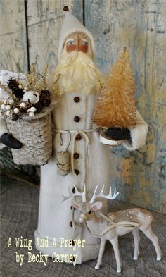 a santa clause holding a basket next to a stuffed deer and a pine cone in his hand