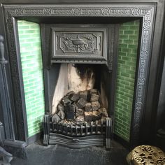 an old fireplace with green tiles and wood