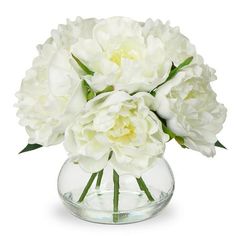 white flowers are in a clear glass vase