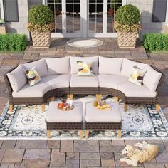 a dog laying on top of a rug in front of a couch and table with pillows