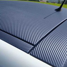 the hood of a car that is made out of carbon fiber and has an antenna attached to it