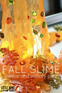 an orange glass vase sitting on top of a table next to some leaves and beads