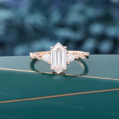 an emerald cut diamond ring on top of a green box