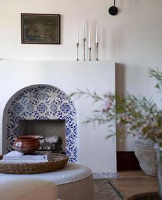 a living room with a fire place and potted plants