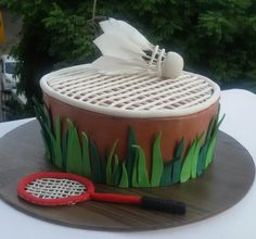 a cake made to look like a tennis racquet and ball on a table