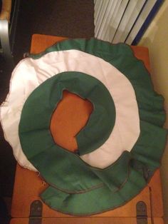 a green and white bag sitting on top of a wooden chair