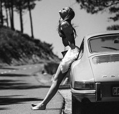 a woman sitting on the hood of a car