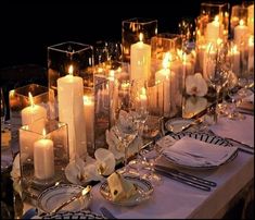 the table is set with candles, plates and silverware for an elegant dinner party