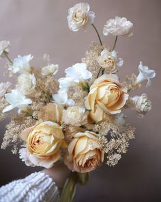 a vase filled with lots of white and yellow flowers