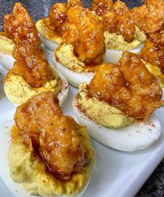 several deviled eggs with chicken wings on them