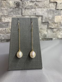 White Pearl 14K Gold Dangle Earrings. The pretty dangle style pierced earrings feature 2 ea White Freshwater Pearl drop shape 11 X 9.5mm AAA high luster with 14 K yellow gold chain dangles (1.3mm) and 14K yellow gold french hook ear wires. They measure 2 3/8 inches from the top of the ear wires. These pearls are beautiful and their luster and overtones are hard to capture in a photo. They are paired with quality solid gold findings. These are hand crafted in our studio. Classic Dangle Earrings With High Luster, High Luster Drop Earrings, Yellow Gold Dangle Pearl Earrings, Yellow Gold Briolette Pearl Earrings For Formal Occasions, Yellow Gold Teardrop Briolette Earrings For Formal Occasions, Yellow Gold Briolette Teardrop Earrings For Formal Occasions, Yellow Gold Briolette Teardrop Earrings For Formal Events, Formal High Luster Drop Jewelry, Fine Jewelry Yellow Gold Dangle Pearl Earrings