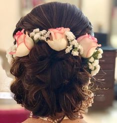 the back of a woman's head with flowers in her hair