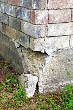 a brick wall that has been torn down and is in the grass next to it