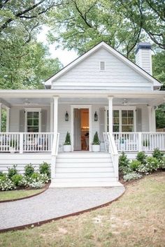 a white house with porches and steps leading to the front door