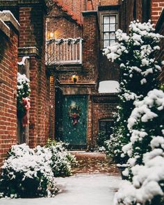 an alley way with snow on the ground and brick buildings in the backround