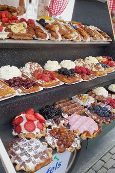 a display case filled with lots of different types of pastries and desserts on top of each other