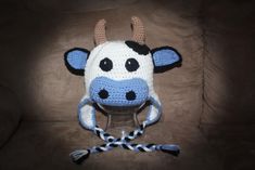 a crocheted cow hat sitting on top of a couch