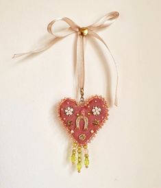 a heart shaped ornament hanging from a ribbon