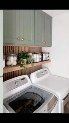 a washer and dryer in a room with green cupboards on the wall