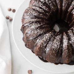 a bundt cake sitting on top of a white plate with chocolate chips around it