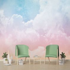 two green chairs sitting next to each other in front of a pink and blue sky