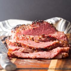 sliced meat sitting on top of a wooden cutting board