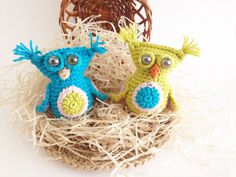 two crocheted owls sitting on top of a nest