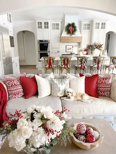 a living room filled with lots of furniture and christmas decorations on top of it's tables