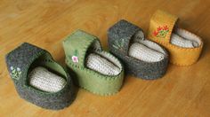 four knitted baby shoes sitting on top of a wooden floor