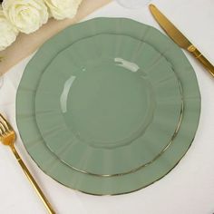 a table setting with flowers and gold cutlery