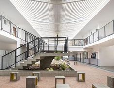 the inside of a building with stairs, benches and tables in front of an open area