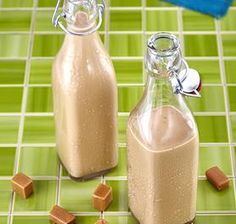 two bottles filled with chocolate milk on top of a green tile floor next to each other