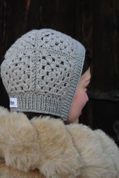 a close up of a person wearing a knitted hat with a tag on it