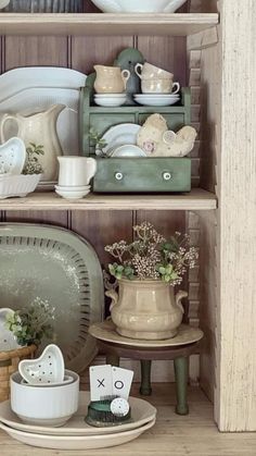 the shelves are filled with dishes and other kitchen items, such as cups, saucers, and plates