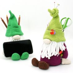 two crocheted gnomes sitting next to each other on top of a white surface