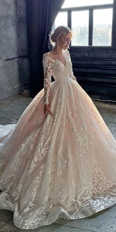 a woman in a wedding dress standing by a window