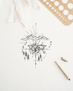 an ink drawing of mountains and trees on paper next to pencils, markers and scissors