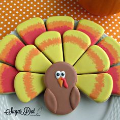 a decorated turkey cookie sitting on top of a white plate