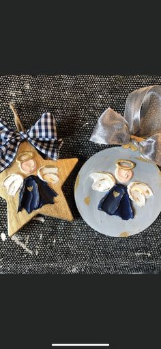 two christmas decorations made to look like angels sitting on top of a plate with a bow