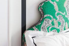 an upholstered headboard with green and white fabric